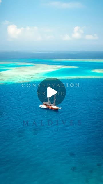 An aerial reel still of a boat anchored beside a reef in the Maldives, titled "Conservation cruise".